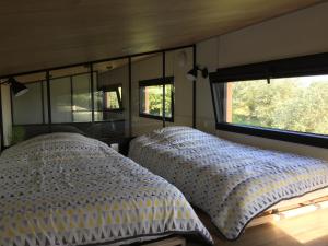 1 dormitorio con 2 camas y un espejo grande en Tiny House sur la cote bretonne en Cléder