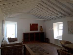 a living room with a white ceiling and two windows at Casa do Alto in Santana