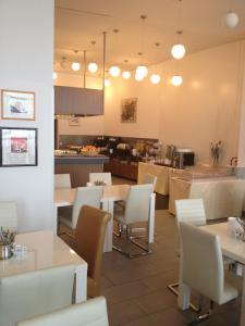 a restaurant with tables and chairs and a kitchen at HB1 Budget Hotel - contactless check in in Wiener Neudorf