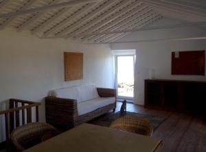 ein Wohnzimmer mit einem Sofa und einem Tisch in der Unterkunft Casa do Alto in Santo António