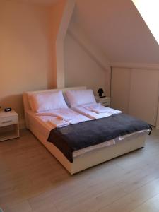 ein Schlafzimmer mit einem großen Bett mit weißer Bettwäsche und Kissen in der Unterkunft Apartment Vatra in Sarajevo