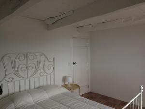 a white bedroom with a white bed and a door at Casa do Ginjal in Santo Antonio +9 photos