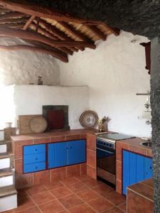 a kitchen with blue cabinets and a stove at Casa do Ginjal in Santo Antonio