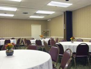 una sala de conferencias con mesas blancas y sillas moradas en Howard Johnson by Wyndham Clifton NJ, en Clifton