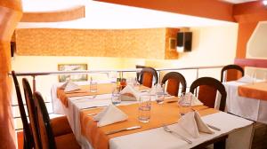 ベルコヴィツァにあるHotel Restaurant Vodenitsataのダイニングルーム(ガラスとナプキンを用意したテーブル付)