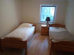 two beds in a small room with a window at Teltow Ferienwohnung in Teltow