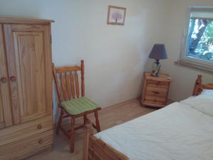 a bedroom with a bed and a chair and a lamp at Teltow Ferienwohnung in Teltow +3 photos
