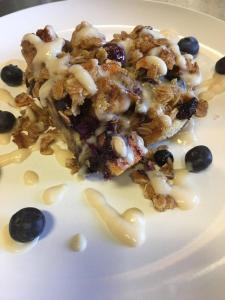 a white plate with a piece of dessert with blueberries at Old Saco Inn in Fryeburg