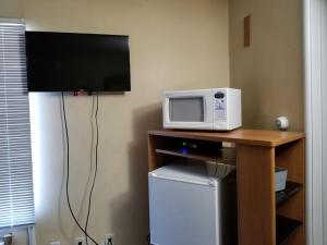 a microwave sitting on top of a table with a tv at Shiva's Travelers Lodge in Niagara Falls