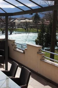 a balcony with two chairs and a view of a river at Apartman River Una in Bihać