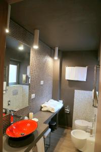 a bathroom with a red sink and a toilet at Hotel Carla in Levanto