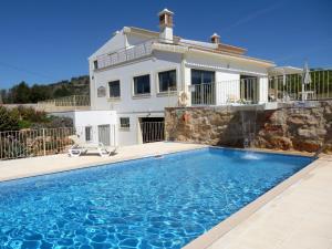a villa with a swimming pool in front of a house at Quinta Sabaudia in Gateiras