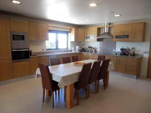 a kitchen with a table and chairs and a kitchen with wooden cabinets at Quinta Sabaudia in Gateiras