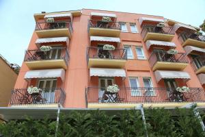 a pink building with flower pots on balconies at Hotel Carla in Levanto