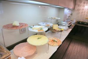 a kitchen with several tables with different types of food at Hotel Carla in Levanto
