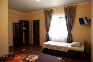 a bedroom with two beds and a window at Emili in Pizunda