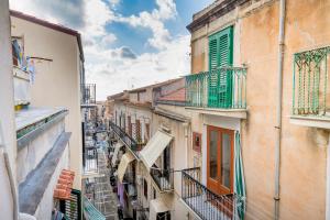Un callejón en un casco antiguo con balcones. en Casa Smeraldo, en Cefalú