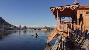 a person in a boat on the water next to a building at Jacqueline houseboat in Srinagar