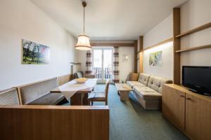 ein Wohnzimmer mit Couch und Tisch in der Unterkunft Apartments Obermayr in Lana