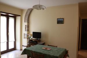 a dining room with a table and a television at B&B La Fonte in Coppito