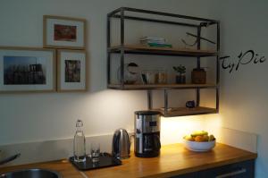 a kitchen counter with a coffee maker and a bowl of fruit at La maison d'hôtes Ty Pic in La Vicomté-sur-Rance