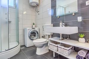 a bathroom with a toilet sink and a washing machine at Sunny apartment Vesna in Split