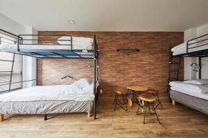 a room with two bunk beds and a table and chairs at Ya Do! KYOTO OKAZAKI in Kyoto