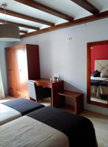 a bedroom with a bed and a desk and a bed at El Rincón del Gallo in Tronchón