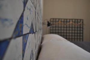 a bed with blue and white tiles on a wall at Casanetina in Noto