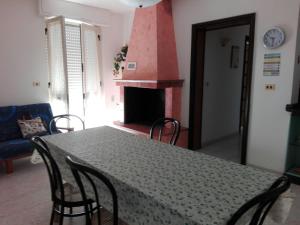 a dining room with a table with chairs and a fireplace at Appartamento Alba vista spiaggia in Torre Mozza
