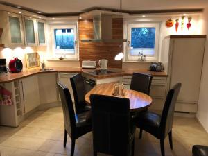 a kitchen with a wooden table and black chairs at Ferienhaus Duenenwald 1 _LANG in Ostseebad Karlshagen