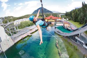 a woman on a zip line over the water at a water park at Haus Marieus in Umhausen