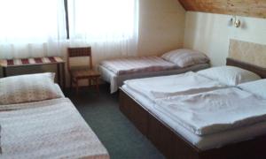 Un pat sau paturi într-o cameră la Hutter Vendégház