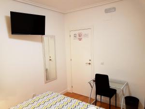 1 dormitorio con cama, escritorio y silla en Pensión Sotelo, en Logroño