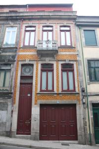un edificio con puertas rojas y balcón en Book House, en Oporto