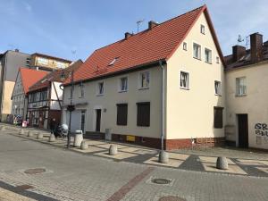 een wit gebouw met een rood dak op een straat bij MP43 in Ustka