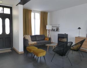 a living room with a couch and chairs and a fireplace at Maison En Ville in Niort