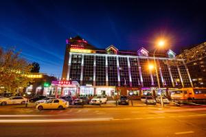 a large building with cars parked in a parking lot at Lipetsk Hotel in Lipetsk