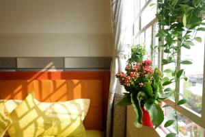 un jarrón de flores sentado en un alféizar de la ventana en Thịnh's House, en Can Tho