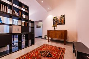 uma sala de estar com uma estante de livros, uma mesa e um tapete em Corso Vittorio Giuliano Family em Palermo