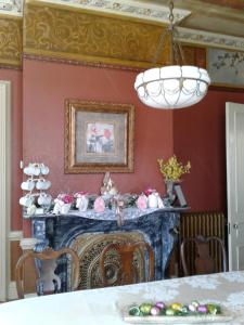 uma sala de jantar com lareira e um lustre em Proctor Mansion Inn em Wrentham
