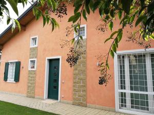 a house with a green door and windows at Casa Vacanze Stefy in Pescantina