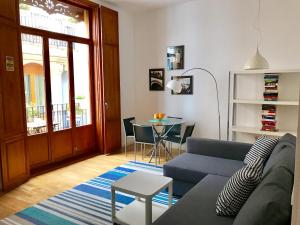 a living room with a blue couch and a table at La casita de Palomar - PalomarGroup in Valencia