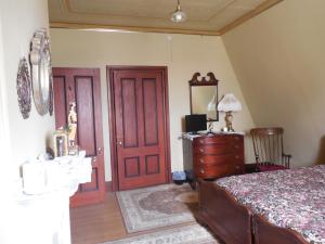 a bedroom with a bed and a dresser and a mirror at Proctor Mansion Inn in Wrentham