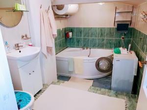 a bathroom with a tub and a toilet and a sink at Līvijas apartamenti in Kuldīga