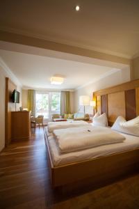 Sankt LeonhardにあるGasthof Schornの広いベッドルーム(ベッド2台付)、リビングルームが備わります。