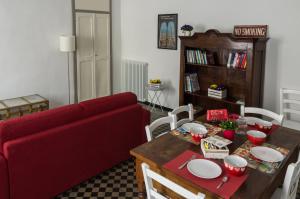 a living room with a red couch and a table at La Tintoria Suites in Asti