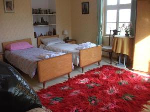 1 dormitorio con 2 camas y alfombra roja en The Pink House, en Polkownik Serafinowo