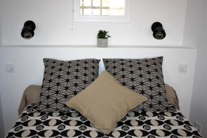 - un lit avec des oreillers en noir et blanc et une fenêtre dans l'établissement Cassis et ses merveilleuses Calanques, à Cassis