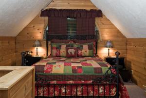 a bedroom with a bed with a red and green quilt at Inn at Ellis River in Jackson